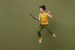 © ViDi Studio - Full body young woman she 20s wear yellow t-shirt jump high run hold use work on laptop pc computer do winner gesture isolated on plain olive green khaki background studio People lifestyle concept.