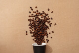 Cup of coffee with coffee beans on paper background. Top view