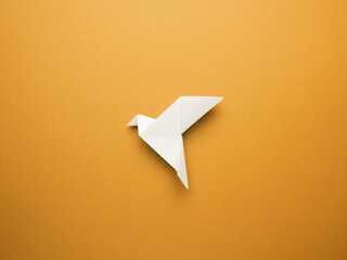 Wall Mural - Origami peace dove on an orange paper background, freedom or peace concept