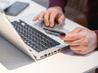 © Konstantin Aksenov - Man is using laptop to pay for online order by credit card. Online shopping or e-commerce. Contactless payment by wireless technologies.