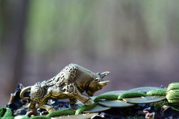 Wall Mural - A bull figurine and a bunch of Chinese coins in close-up. A religious symbol.