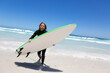 © Austockphoto - Child in wetsuit carrying surfboard out of the water
