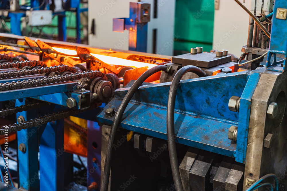 Machine for induction heating of metal. A metal rod heated in an induction furnace. Hot metal processing. Metalworking in the industrial workshop at the factory.