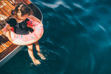 Wall Mural - Baby girl swimming with Inflatable ring in the sea.