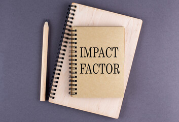 Wall Mural - Word IMPACT FACTOR on notebook with pencil on the grey background