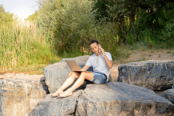 Wall Mural - Busy entrepreneur talking on the phone and running his digital business from a getaway in nature