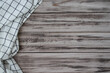 Wooden surface with a textile napkin or linen checkered kitchen towel on the side. Copy space for text. Layout for design.