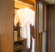 Two elegant white bathing gowns hanging in wardrobe in hotel nicely prepared to serve for guests
