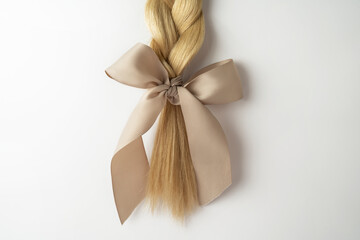 Wall Mural - A strand of blonde hair lying on a white background