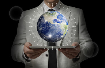 Wall Mural - internet technology concept. man holding tablet and virtual icon of earth on dark background