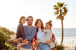 © Erin Brant/Stocksy - Happy family with two daughters near ocean