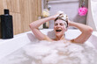 © Oleksii Syrotkin/Stocksy - Happy naked woman with lather on head  resting in bathtub