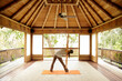 © Trinette Reed/Stocksy - Woman doing yoga in Japanese yoga deck pavilion
