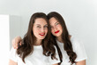 © shapovalphoto - Two beautiful women twin sisters posing white background