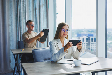 Wall Mural - Portrait of a female manager in formal attire doing office work and talking on the phone, a successful european female boss in optical glasses for vision correction, posing at her desk