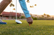 healthy Senior Citizen Woman puts golf ball on tee 