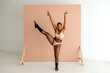 © Erin Brant/Stocksy - High kick by woman with thong over fishnets