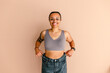 © Erin Brant/Stocksy - Smiling hispanic woman in bra and jeans