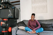 © Ezequiel Giménez/Stocksy - Excited African American lady filming video at home