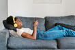 © Ezequiel Giménez/Stocksy - Black teenager listening to music and using cellphone