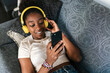 © Ezequiel Giménez/Stocksy - Black teenager in headphones scrolling social media