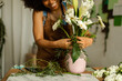 © Valentina Barreto/Stocksy - Cropped florist preparing vase with flowers at work