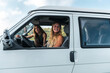 © Manu Prats/Stocksy - Millennial women driving camper van during surf trip