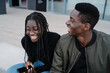 © Manu Padilla/Stocksy - Happy black couple laughing on stairs on street