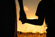 © kieferpix - Mother little child silhouette holding hands walking in a grass field at sunset