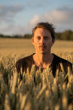 Portrait Of Handsome Man Standing In Wheat Field