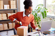 © ALTO IMAGES/Stocksy - Black employee entering parcel data into laptop