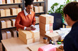 © ALTO IMAGES/Stocksy - Black woman packing goods with colleague