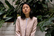 © Bisual Studio/Stocksy - Asian businesswoman resting near lush plants
