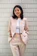 © Bisual Studio/Stocksy - Optimistic Asian businesswoman with hands in pockets