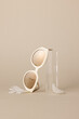 © Nicole Mason/Stocksy - pair of sunglasses with gold lenses leaning on acrylic prop