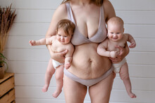 Woman In Lingerie Posing Holding Two Babies