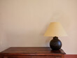 © Miquel Llonch/Stocksy - Home decoration with vintage lamp and furniture, warm plain wall.