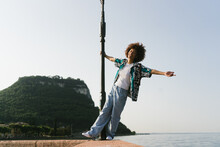 Happy Woman Hanging From A Pole Outdoors
