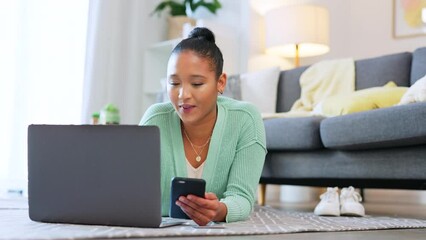 Aufkleber - Young female student shopping online while relaxing at home. A woman browsing the internet and checking social media notifications on her phone while lying on the floor of her house