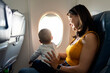 © Santi Nuñez/Stocksy - Mom Holds Son On Airplane