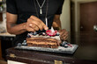 © Sean Locke/Stocksy - Loft: Man Puts Birthday Candle In Fancy Cake
