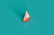 © Giada Canu/Stocksy - a pink sail boat on a blue background
