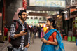 © Dream Lover/Stocksy - Indian young couple standing in a busy road and making conversation