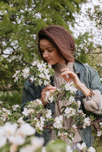 Woman Delicately Touching Blooming Branch