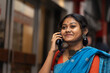 © Dream Lover/Stocksy - Happy  Young Woman Wearing Traditional Sari Speaking In A Smartphone