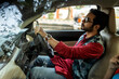 © Dream Lover/Stocksy - A man wearing traditional dress sitting inside car holding steering