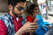 © Dream Lover/Stocksy - Indian young couple sitting inside a car and browsing smartphone