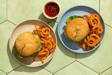 Burgers In Colorful Plates On Green Tile Background