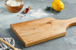 © Ryzhkov - Food mockup. Empty wooden board on concrete table with cooking  ingredients. Wooden board  with spices, greens and tomatoes for menu. Food menu mockup. Cooking composition with empty place.