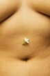 © Sophia Hsin/Stocksy - Single jasmine flower next to belly button